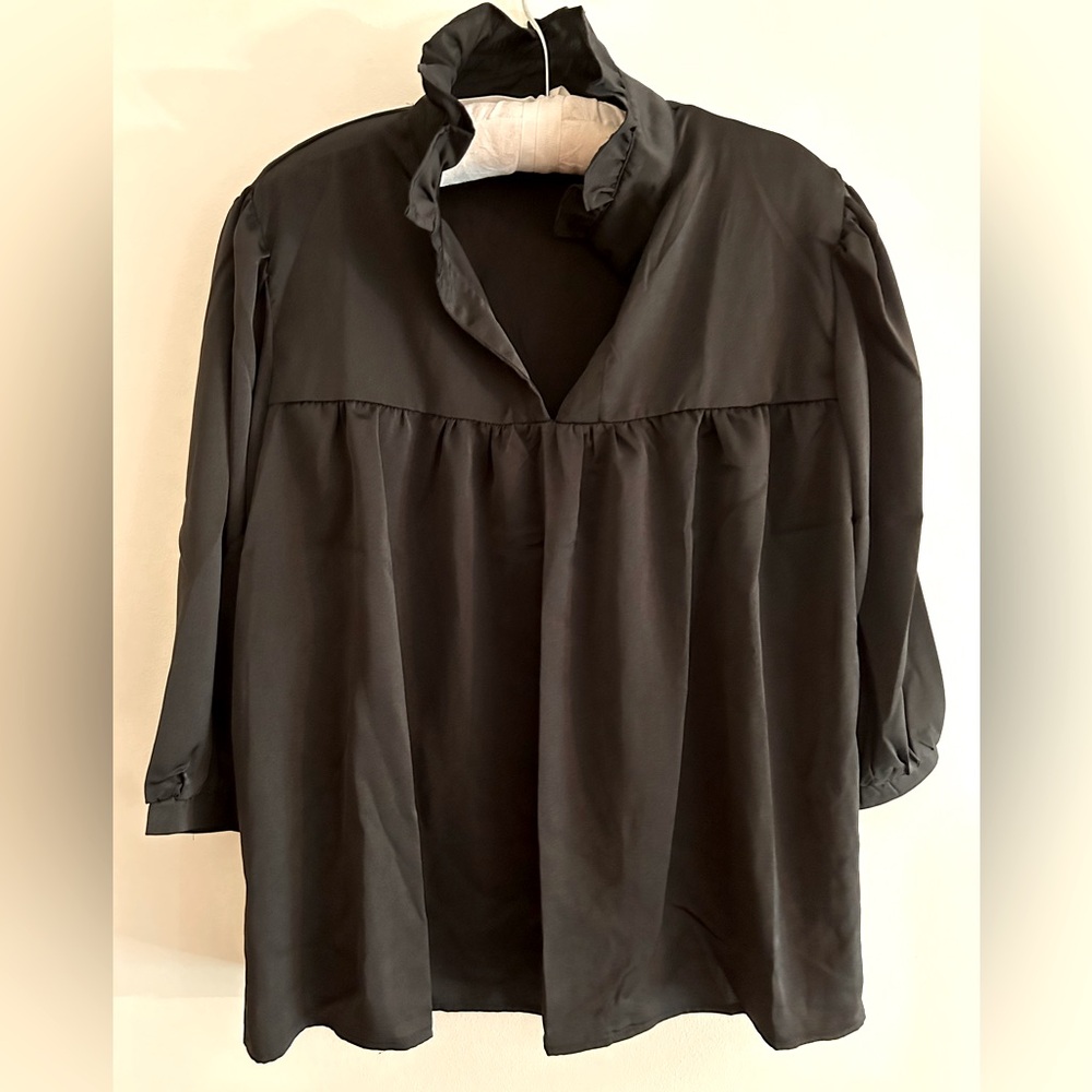 Cute black silky top with ruffle collar.  Pair with pants, skirts and leggings.